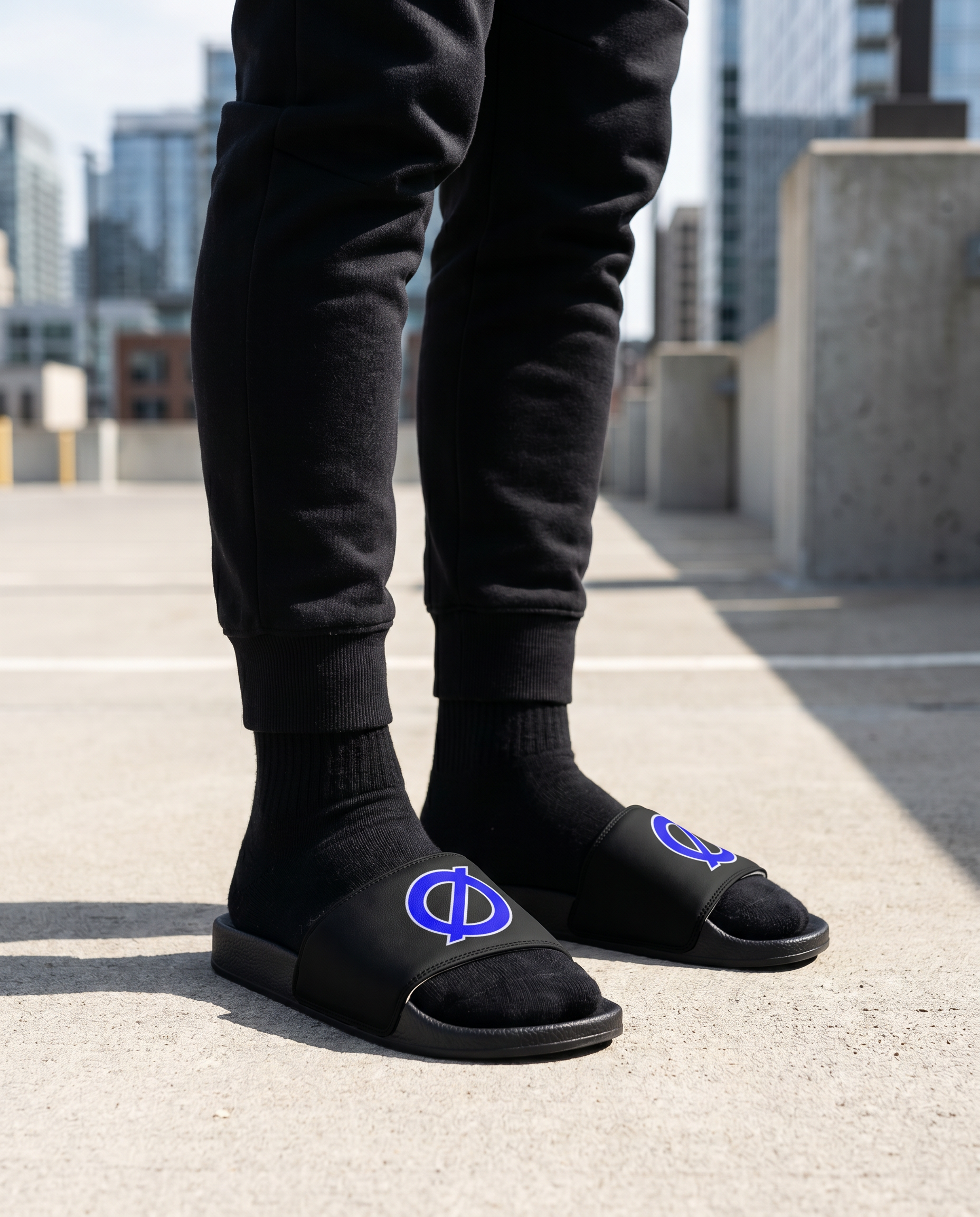 Person standing in UNCØDED Ø Slides with blue Ø logo streetwear sandals #group:black-blue